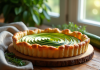 Tarte courgette et chèvre fraîche sortie du four sur une table en bois